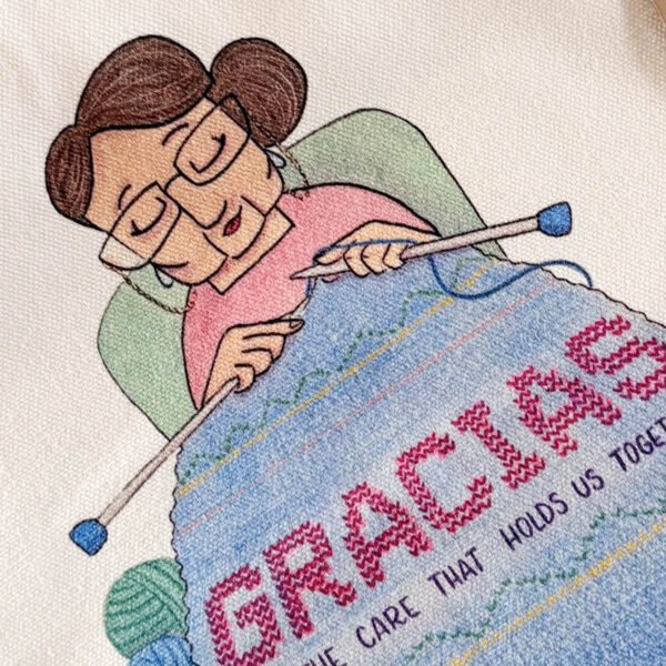 Illustrated cotton tote bag featuring a Latin American woman knitting the word gracias, created for United's Aged Care Employee Day.